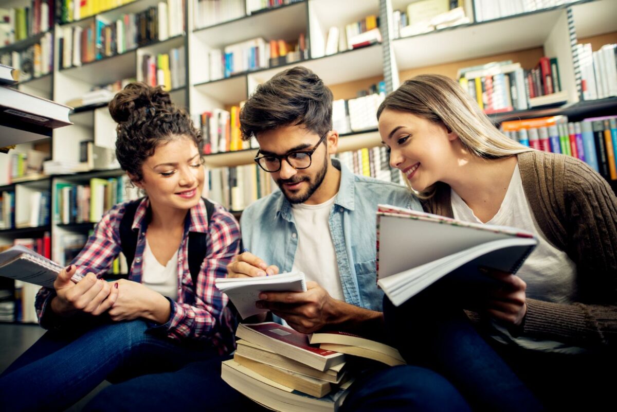 Students comparing notes in university library