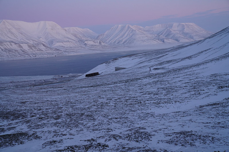 Vast snowy and icy landscape at dawn or dusk, with Svalbard Seed Vault located in the centre
