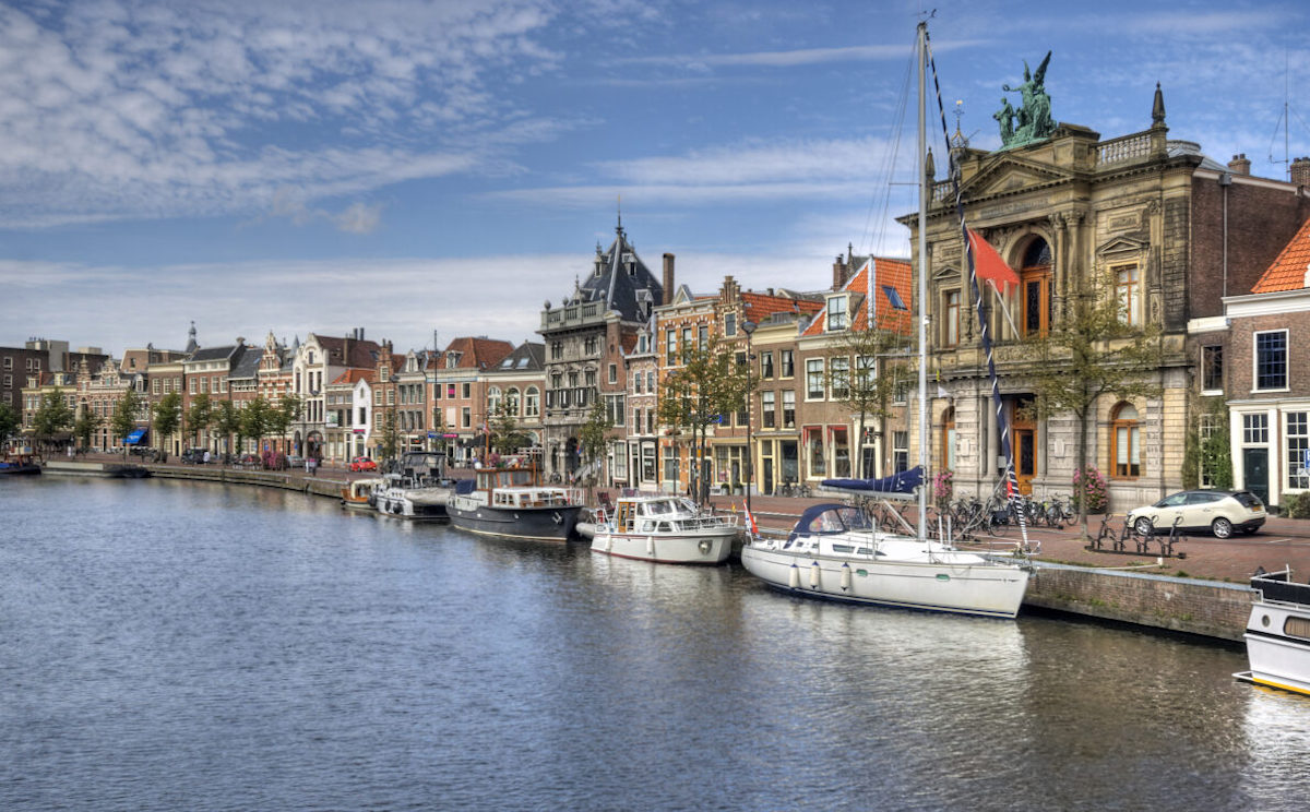 Canal with boats and historical houses in Haarlem, Holland