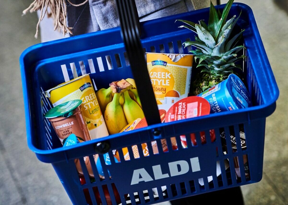Blue basket with 'Aldi' logo, full of own-brand pot products and bananas and pineapple