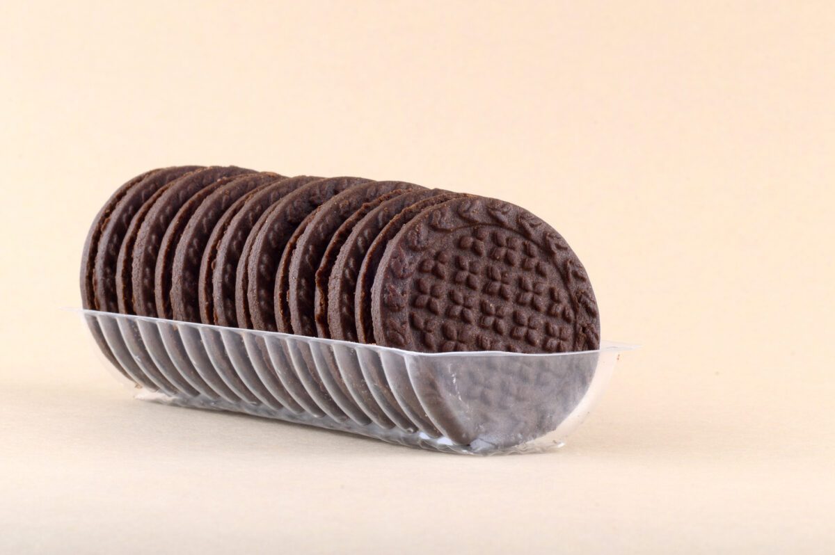 Chocolate and cream biscuits or Cookies in plastic tray on beige background