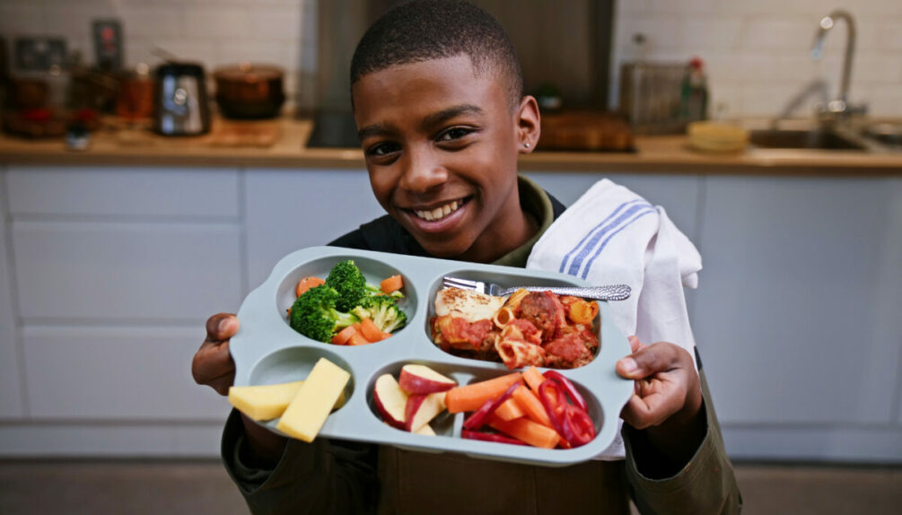 Omari McQueen holding school lunch plate