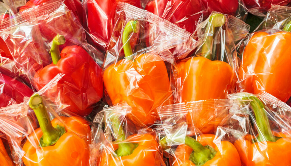plastic wrapped orange and red bell peppers