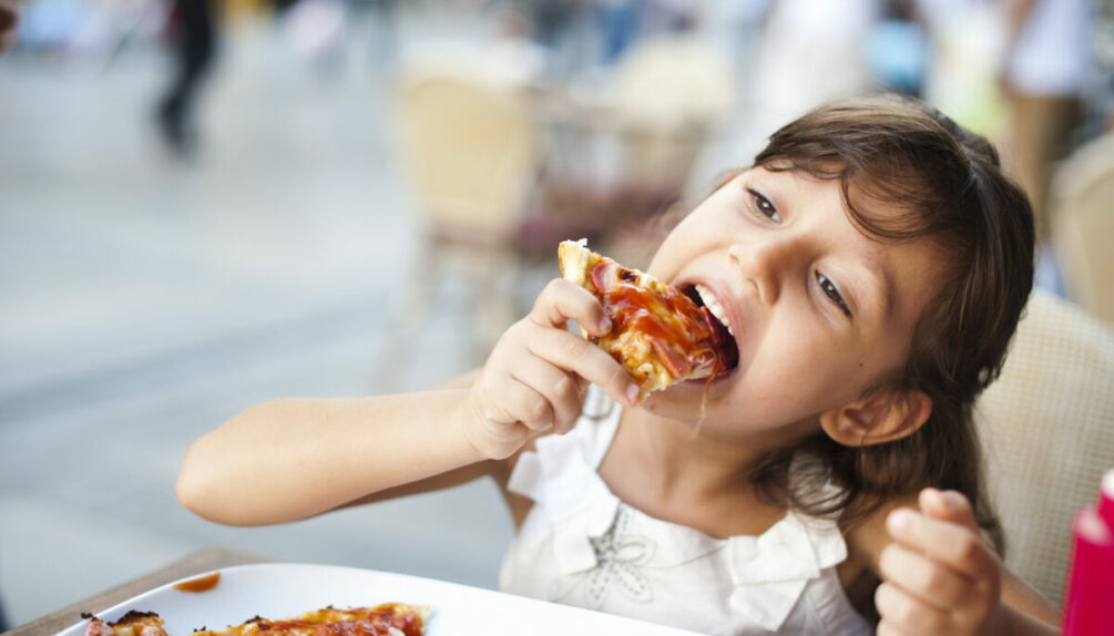 little girl eating pizza