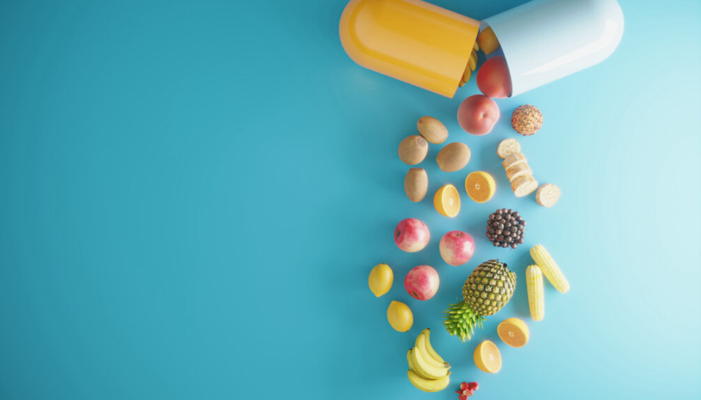 a yellow and blue opening capsule with fruits pouring out on blue background