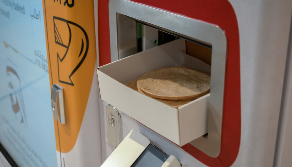 Close up shot of fresh Arabic bread produced by the vending machine, dispensed in a cardboard tray