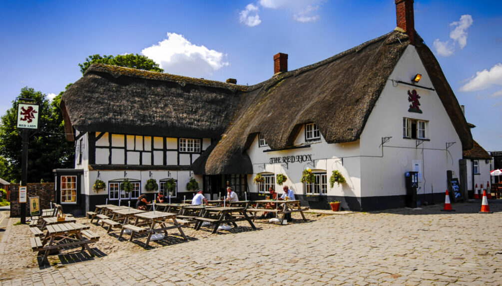 People outside the Red Lion pub at Avebury in Wiltshire, UK