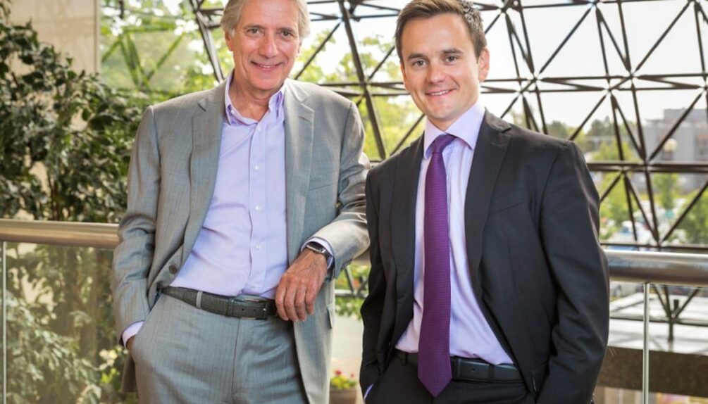 Image of Malcolm and Richard Walker standing next to each other wearing suits