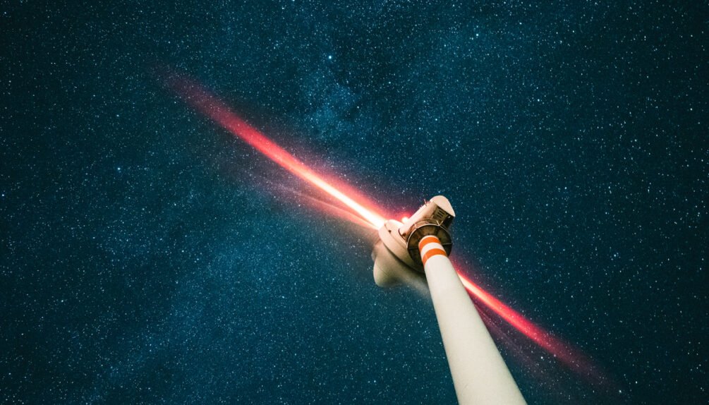 A wind turbine under the stars at night.
