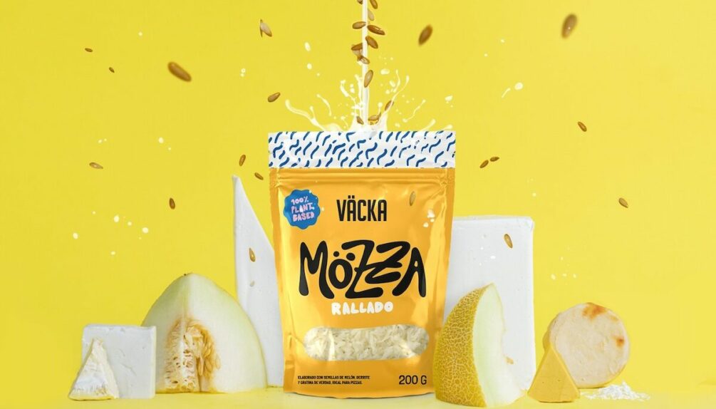 plant-based grated cheese in yellow packet on yellow background alongside plant-based cheese blocks and canteloupe melon slices