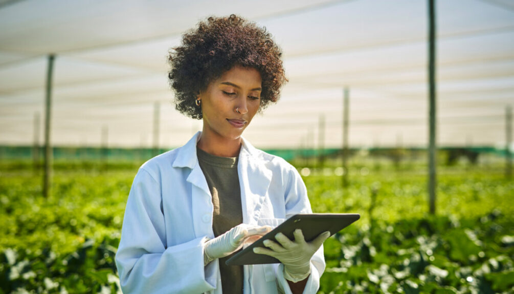 scientist holding ipad on a farm