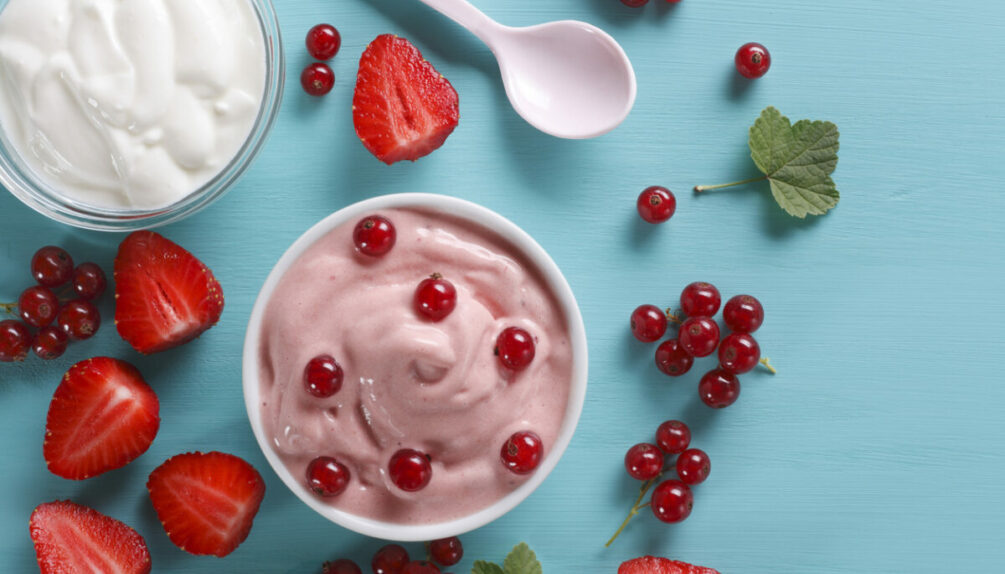 Yogurt and berries on blue table