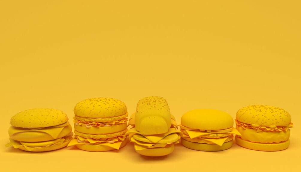 hamburgers, cheeseburgers ultra processed foods on yellow background