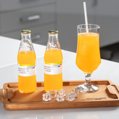 A selection of orange-coloured functional drinks on a wooden board