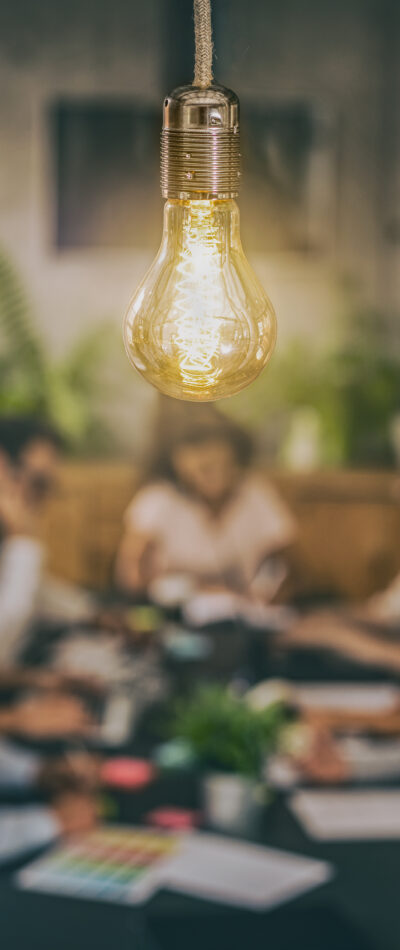 Lightbulb with desk of people