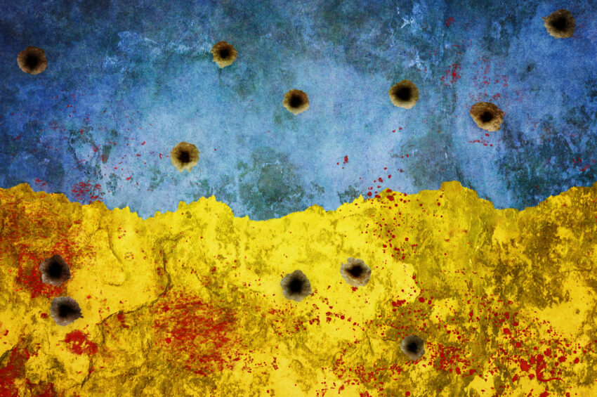 bullet holes in wall painted in Ukraine flag colours